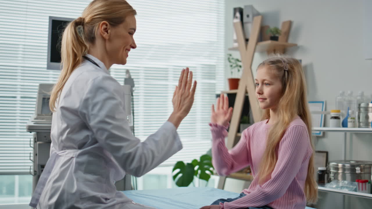 Medical worker consulting kid during appointment. Closeup cheerful young patient