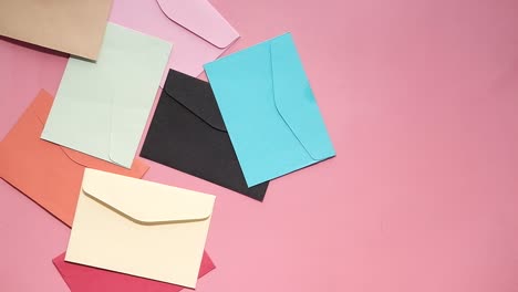 sobres de colores sobre un fondo rosado