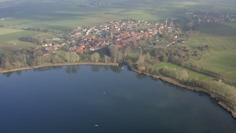 Drone-aerial-of-the-typical-german-village-Seeburg-located-at-the-Seeburger-See-on-a-beautiful-Sunday-morning