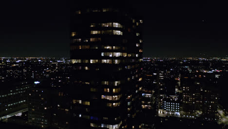 Aerial-drone-tilt-up-shot-of-a-multi-storied-office-building-at-night-time-in-Chicago-in-USA