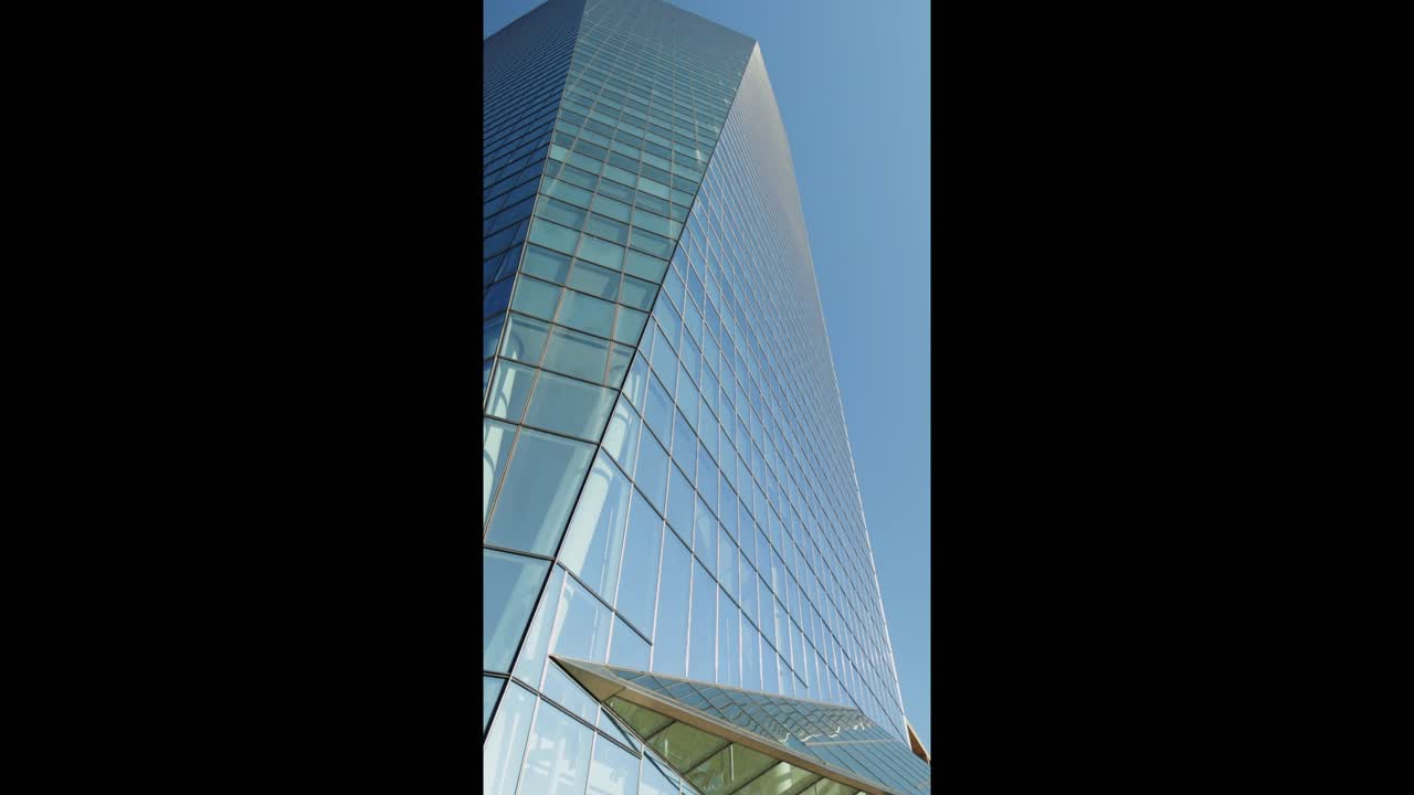 Grattacielo moderno in vetro con facciata riflettente in panoramica verso l'alto