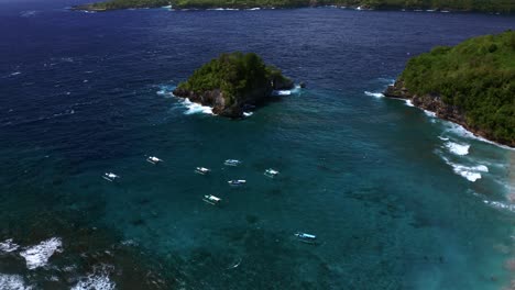 boats on the turquoise seascape of crystal bay beach in nusa penida, bali, indonesia - aerial shot