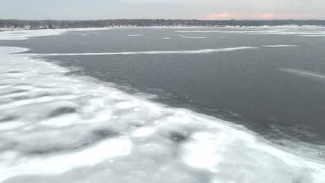 aerial view of a partially frozen lake on a cloudy afternoon