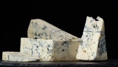 los pedazos de queso brie en una tabla de piedra giran lentamente.