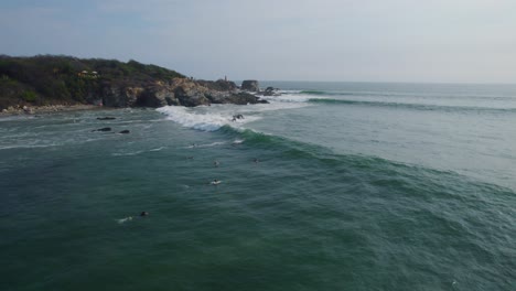 Surfers-surfing-next-to-rocks