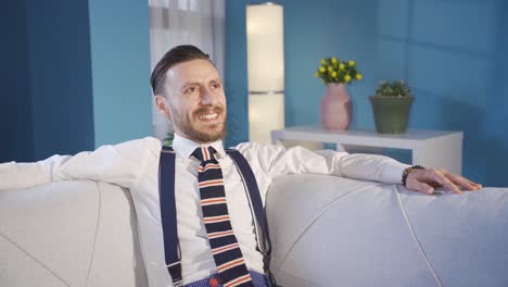 Stylish-and-handsome-man-sitting-on-sofa-alone-at-home-and-dreaming-of-happy-days.