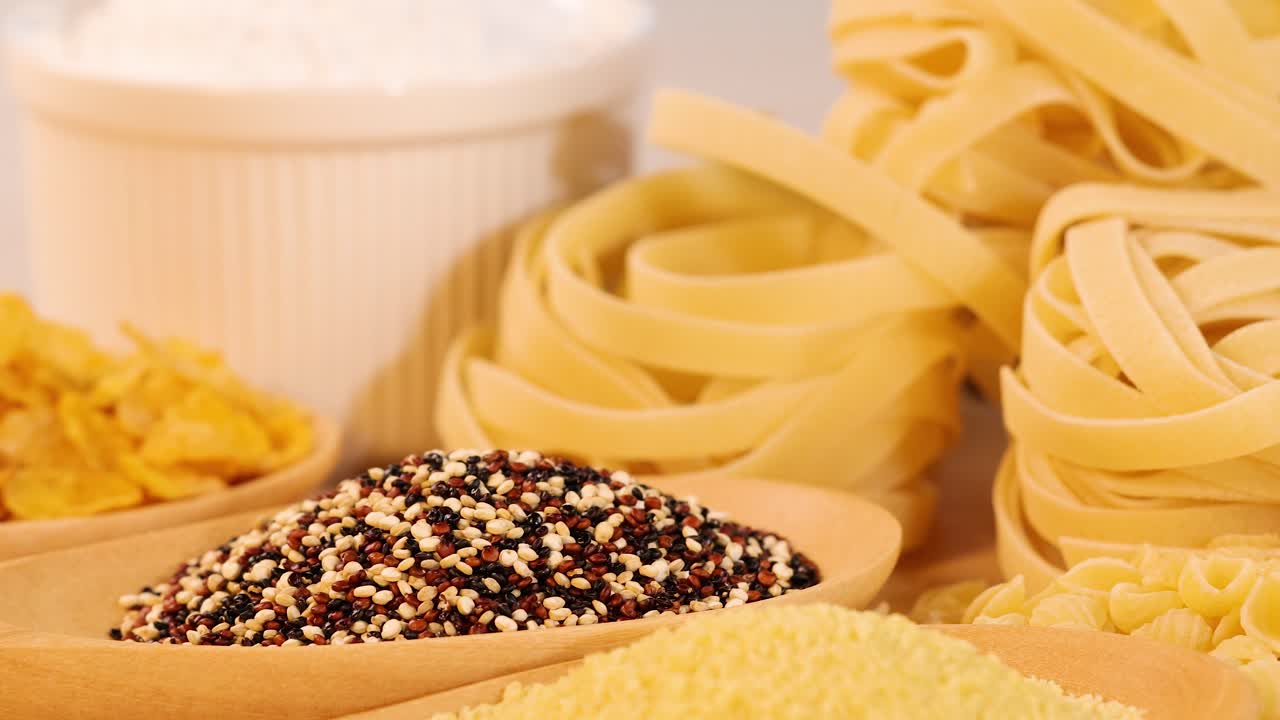 A variety of grains, pasta, and bread arranged under soft lighting, highlighting textures and colors in a warm setting