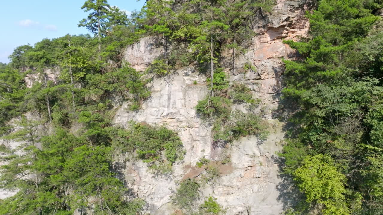 Aerial view rotating in front of a rocky mountain wall in Zhangjiajie, China