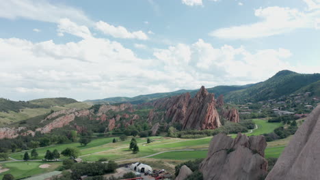 campo de golf de punta de flecha en littleton colorado con césped verde, rocas rojas y cielos azules