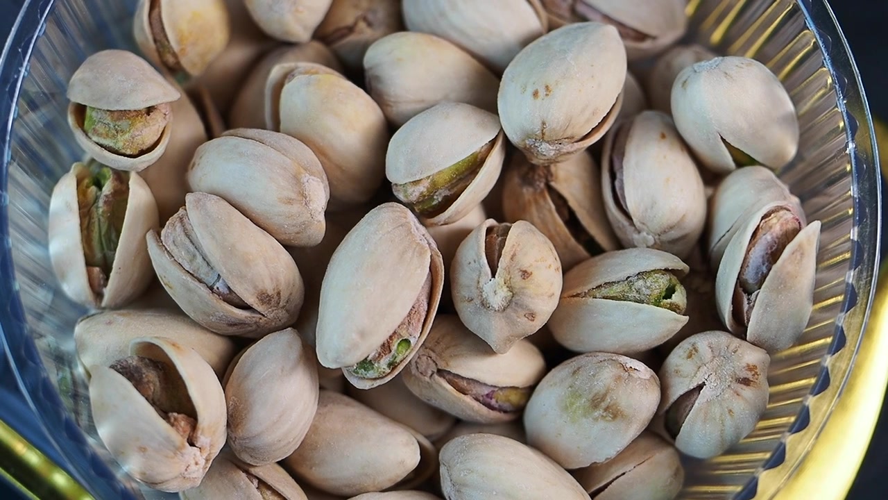 Primo piano di pistacchi in una ciotola di vetro su un vassoio