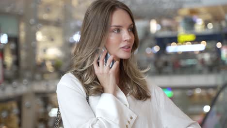 mujer hablando por teléfono en un centro comercial