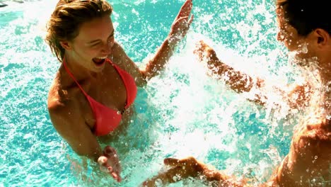 sexy couple splashing in the pool together on holidays