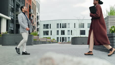 business people shaking hands outside a building