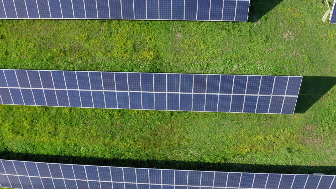 аэрофотосъемка: вид сверху вниз на панели солнечной электростанции ecology в зеленом поле в солнечный день