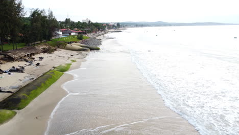 Aerial,-polluted-beach-with-barriers-to-prevent-flooding-from-rising-sea-level