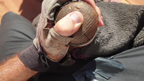 primer plano de la mano sujetando el poste de la silla montando camello a través del vasto y remoto desierto árabe de wadi rum en jordania, oriente medio