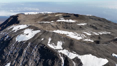 drone shot of uhuru peak on mount kilimanjaro flying towards the volcanic crater. wide rotating aerial shot