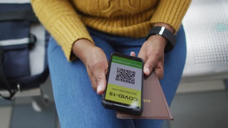mujer de negocios afroamericana preparando la certificación de covid-19 en un teléfono inteligente