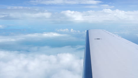 scene of airplane wing flying over clouds