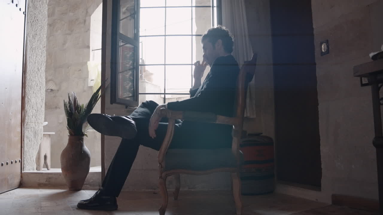 열린 창문  의자에 앉아 있는 남자