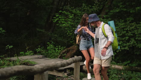 couple hiking in forest on wooden bridge