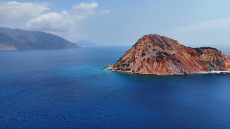 greek rocky island in blue sea. stunning blue waters lap against the rugged coastline of an island in greece, highlighting its natural beauty