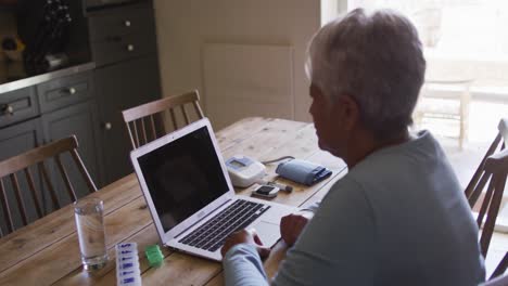 Senior-mixed-race-woman-having-online-medical-consultation-using-laptop