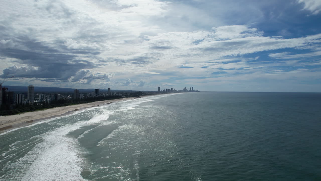 золотое побережье с городским горизонтом на расстоянии под облачным небом, взгляд с воздуха