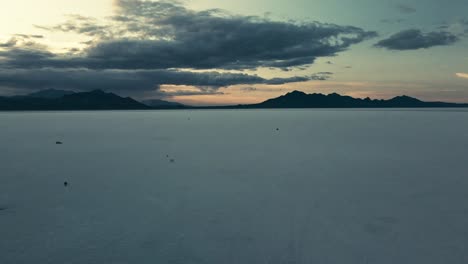 Aerial-pan-looking-at-a-mountain-landscape-with-the-sun-on-the-horizon