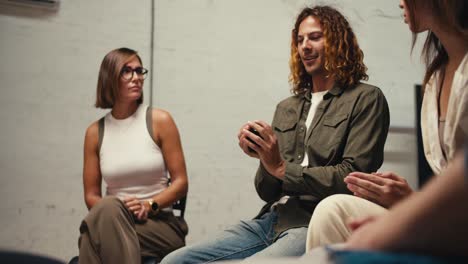 Participants-pass-each-other-a-black-ball-and-tell-each-other-about-themselves.-A-man-with-curly-hair-and-a-brunette-girl.-Getting-to-know-each-other-in-group-therapy