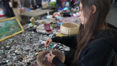 woman examining jewelry at a market