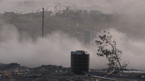 IDF-military-jeeps-pass-on-a-dusty-road-against-the-backdrop-of-buildings-destroyed-by-Israeli-missile-attacks-in-the-Gaza-Strip