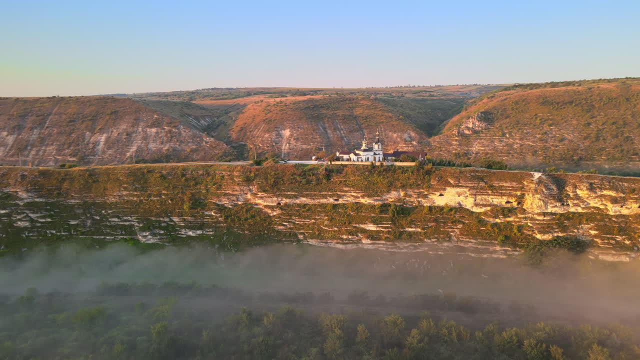 Aerial drone view of the Old Orhei at sunset. Valley with river and fog, monastery located on a hill in Moldova