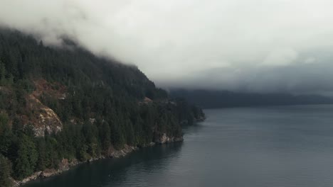 Misty-Clouds-Over-Tranquil-Seascape-And-Dense-Forest-Mountains-In-British-Columbia,-Canada