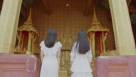 two asian girls travel in the temple, slow motion