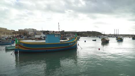 multi-coloured traditional maltese fishing boats decorated with osiris eyes in the harbour of marsaxlokk