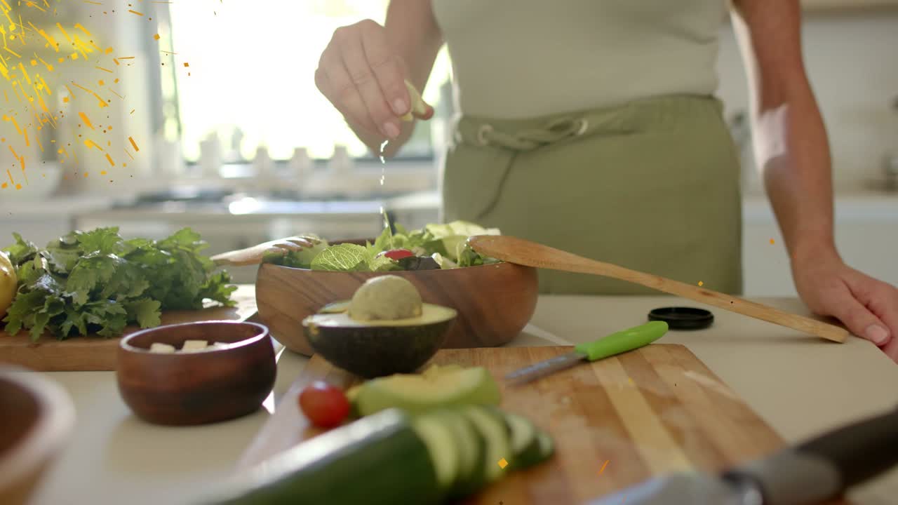 Cocinero exprimiendo limón y rociando aceite sobre la ensalada para aderezar, con etiquetas animadas que identifican la comida cerca de las manos