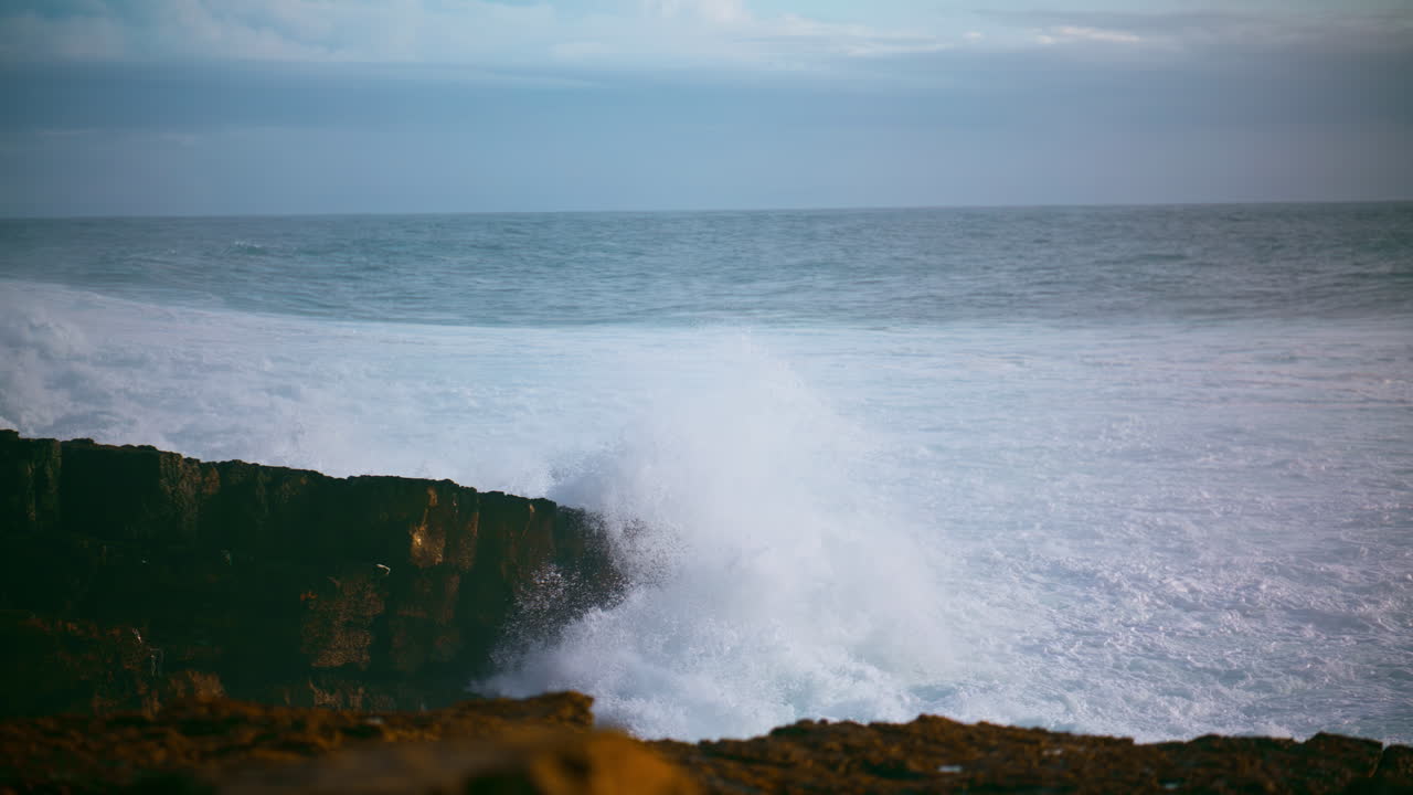 hermosas olas chocando contra la orilla rocosa. el mar espumoso golpeando la costa salvaje
