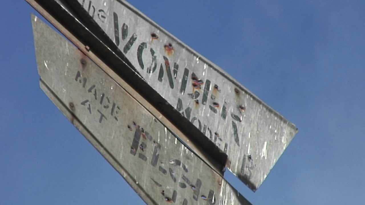 작은 바람에 가볍게 움직이는 빈티지 풍향계의 부식된 블레이드의 중간 샷