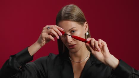 mujer aplicando máscara y lápiz labial