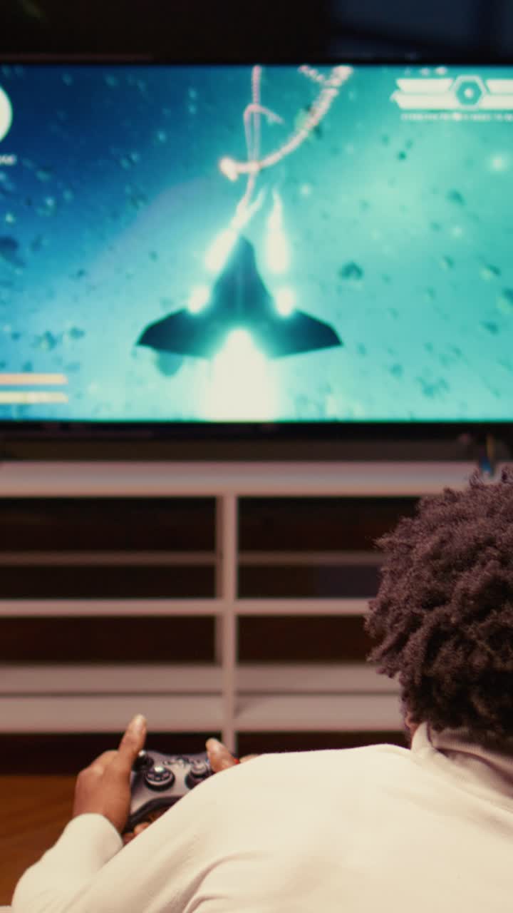 Video verticale di un gamer che gioca a un videogioco arcade sparatutto spaziale classico su una smart TV moderna