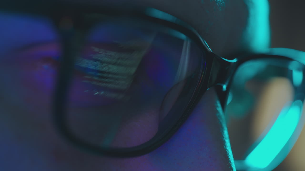 Close-up view of person wearing glasses, with a reflection of a computer screen