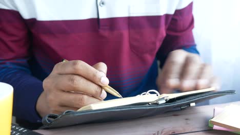 persona que escribe en un cuaderno