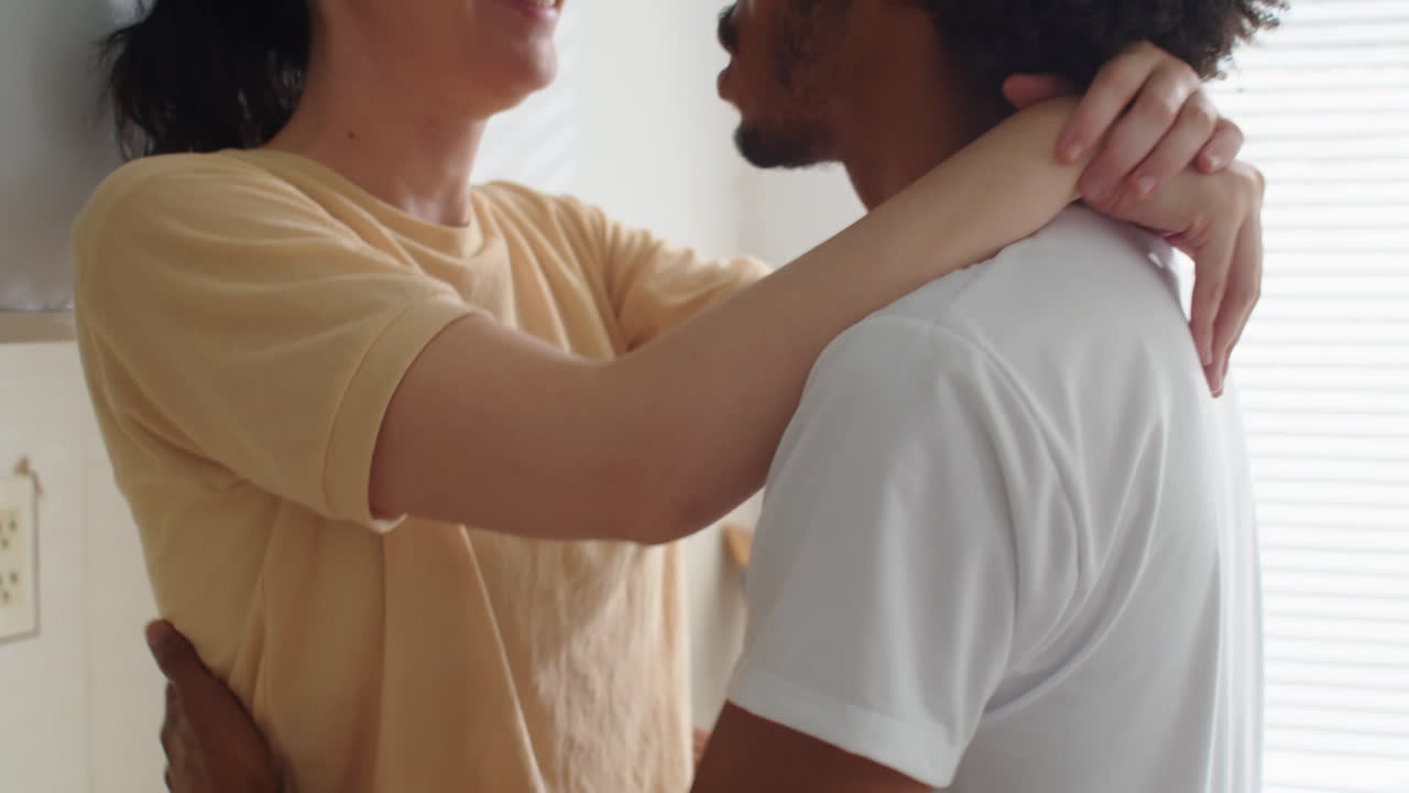 Biracial Spouses Hugging, Kissing and Talking at Home
