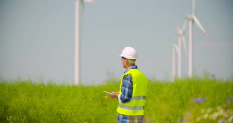 Ingenieur-Mit-Digitalem-Tablet-Während-Der-Inspektion-Von-Windkraftanlagen-Im-Windmühlenpark-1