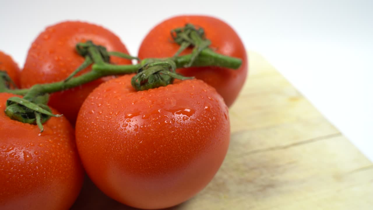 나무판에 물방울이 있는 빨간 포도 토마토 어리 위에서 오른쪽에서 왼쪽으로