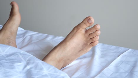 close-up of a person's feet resting on a bed