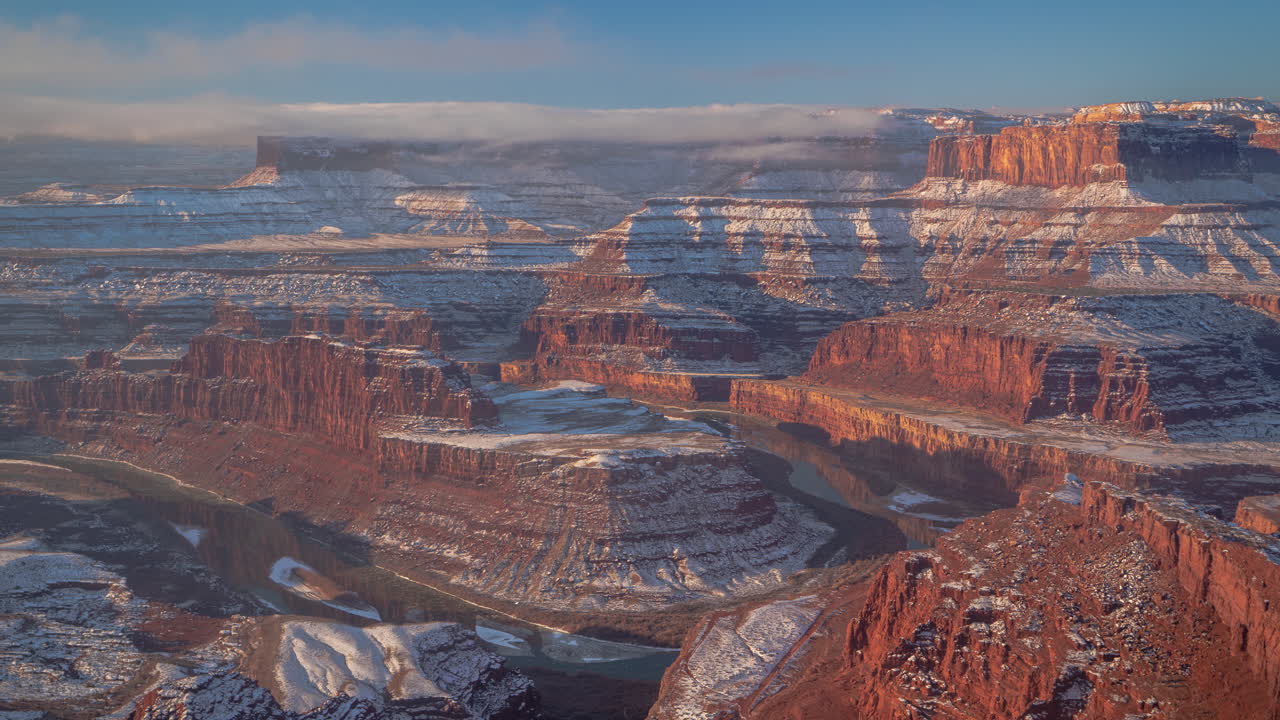 Time-lapse, skyer og tåke over snødekte røde fjellformasjoner i Utah-ørkenen, USA