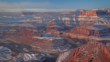 time lapse, clouds and mist above snow capped red rock formations in utah desert usa