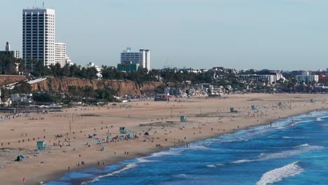 Aerial-drone-shot-showing-the-very-busy-Santa-Monica-Beach-on-a-nice-day